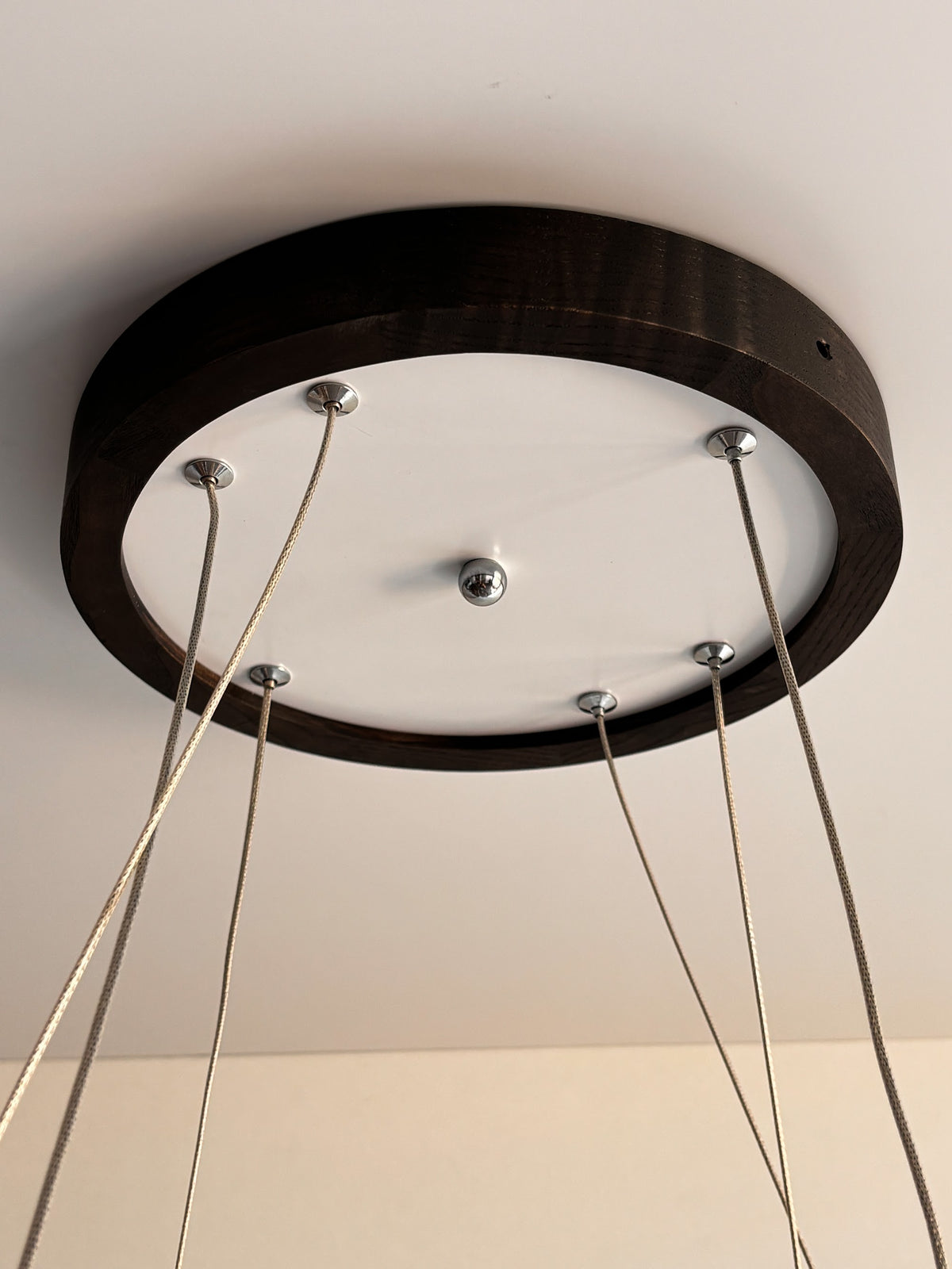 Black wood ring LED pendant light over dining table — photo 4