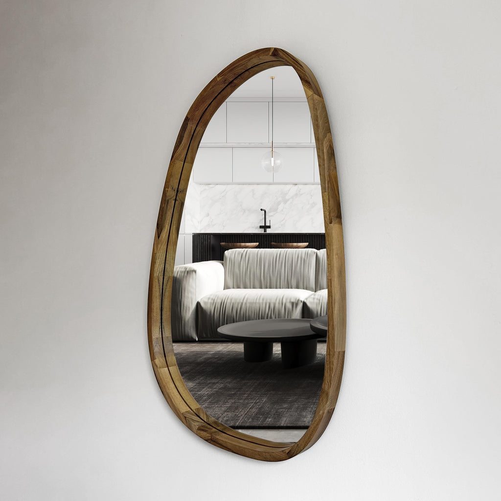 Asymmetric wood wall mirror in an organic pebble shape on a white wall