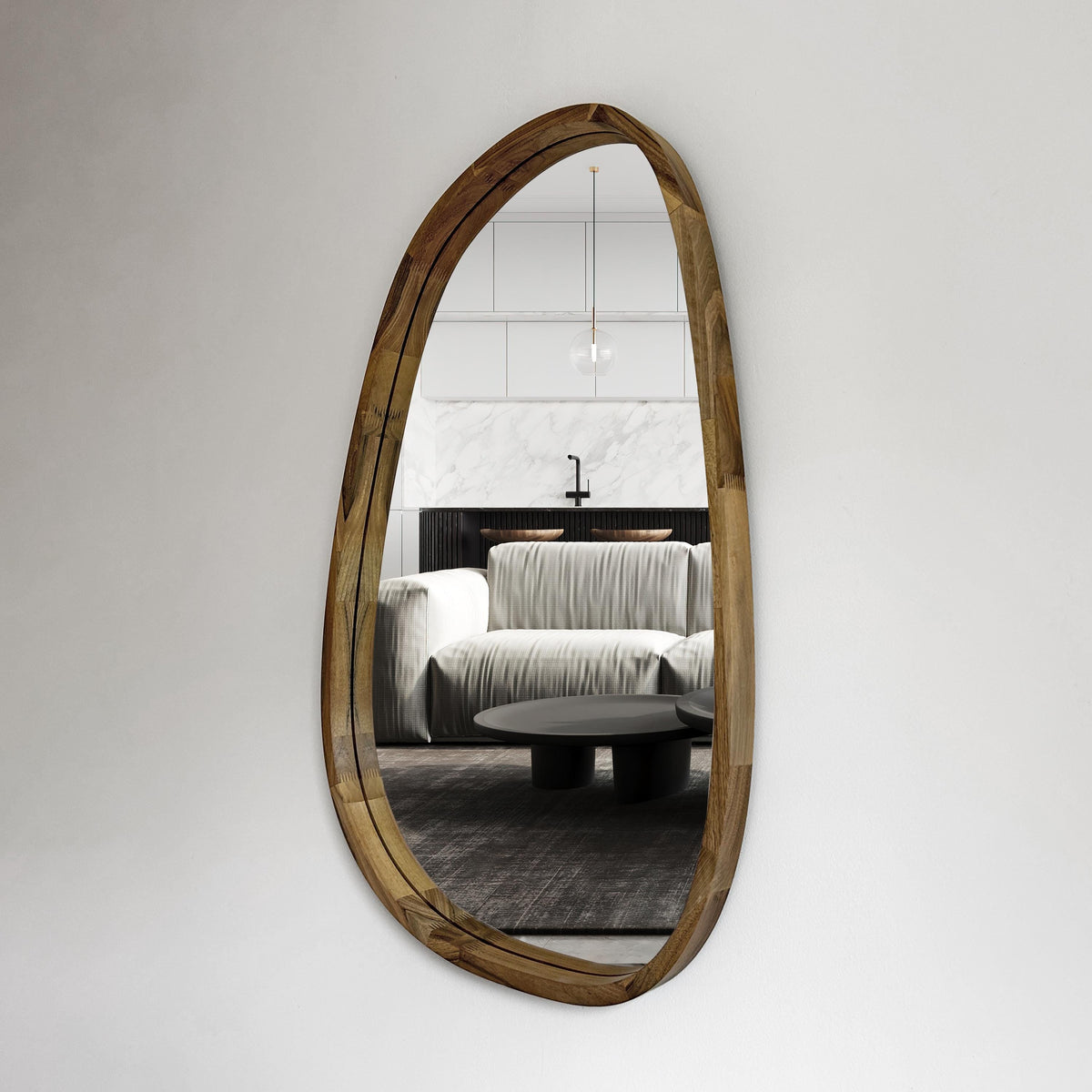 Asymmetric wood wall mirror in an organic pebble shape on a white wall