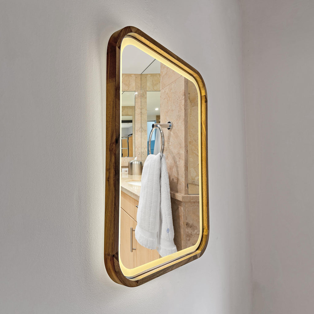 Square LED wood mirror mounted on a bathroom wall with the light on