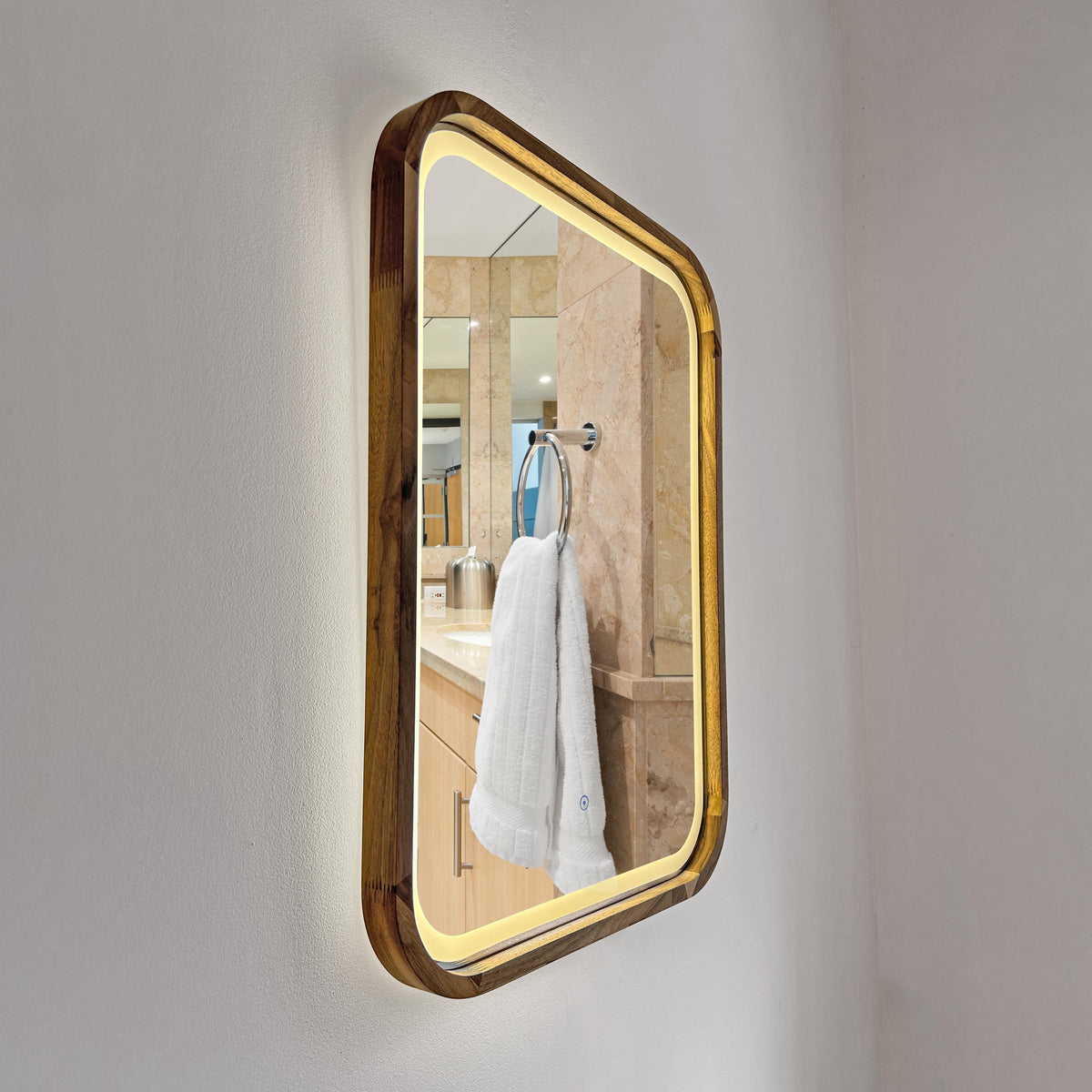 Square LED wood mirror mounted on a bathroom wall with the light on