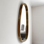 Angled view of the asymmetric mirror showing the solid wood frame profile