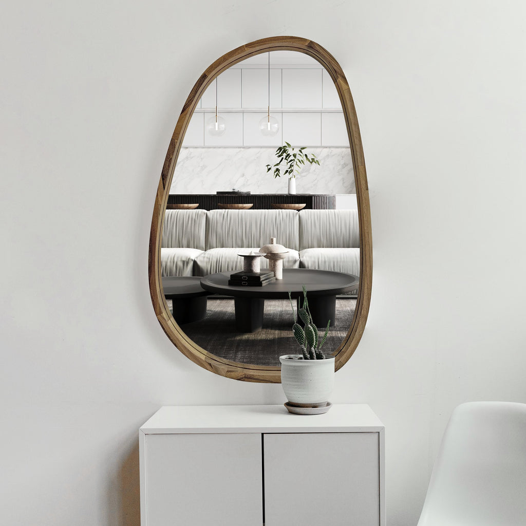 Irregular wall mirror in solid wood above a white sideboard