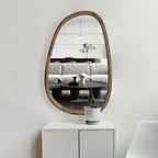 Irregular wall mirror in solid wood above a white sideboard