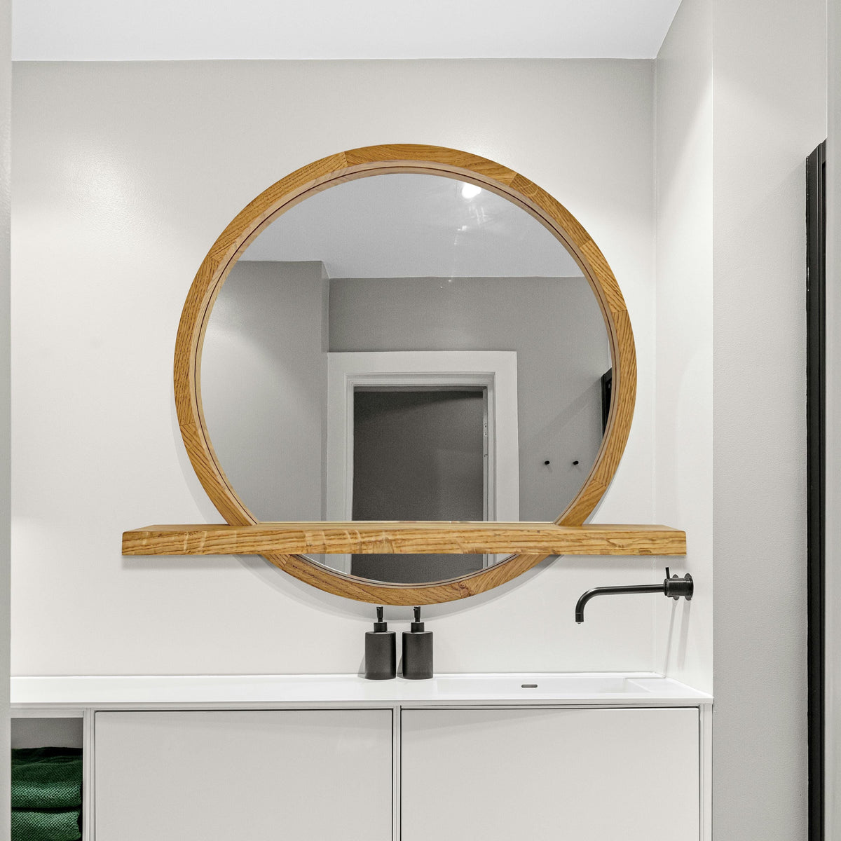 Round mirror with shelf in a bathroom