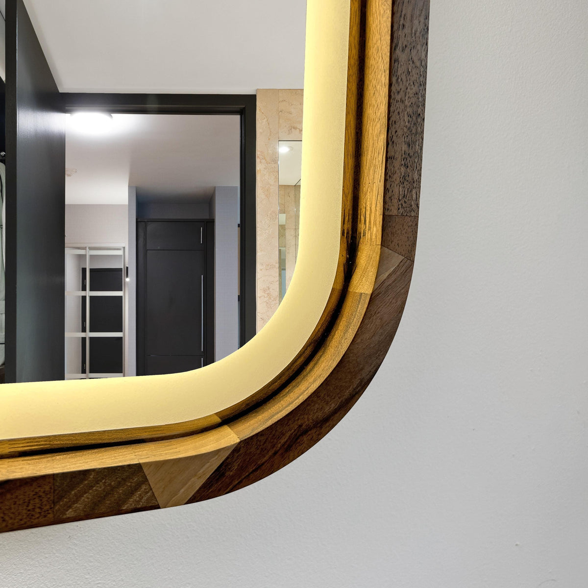 Close-up of the mirror corner: solid wood frame and LED glow
