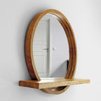 Round wood mirror with shelf mounted in an entryway
