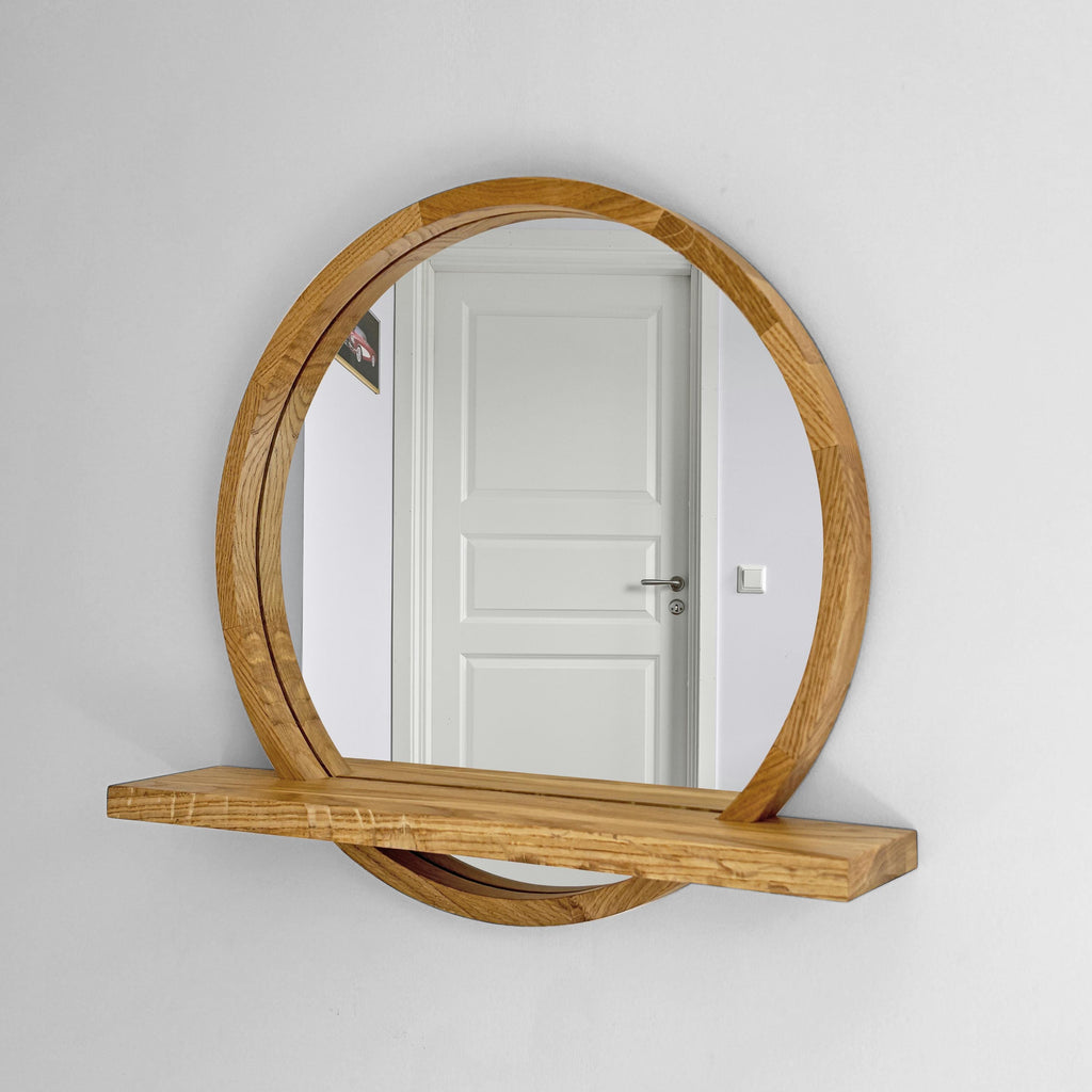 Round wood mirror with shelf on a white wall