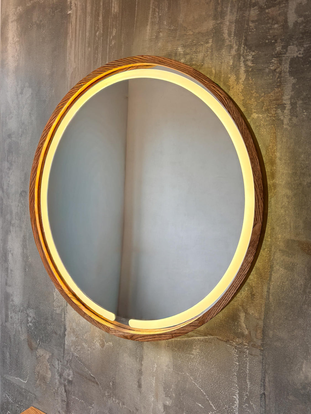 Round LED wood mirror on a textured wall