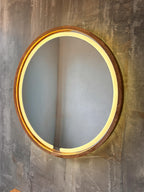 Round LED wood mirror on a textured wall