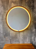Round LED wood mirror with a soft warm glow