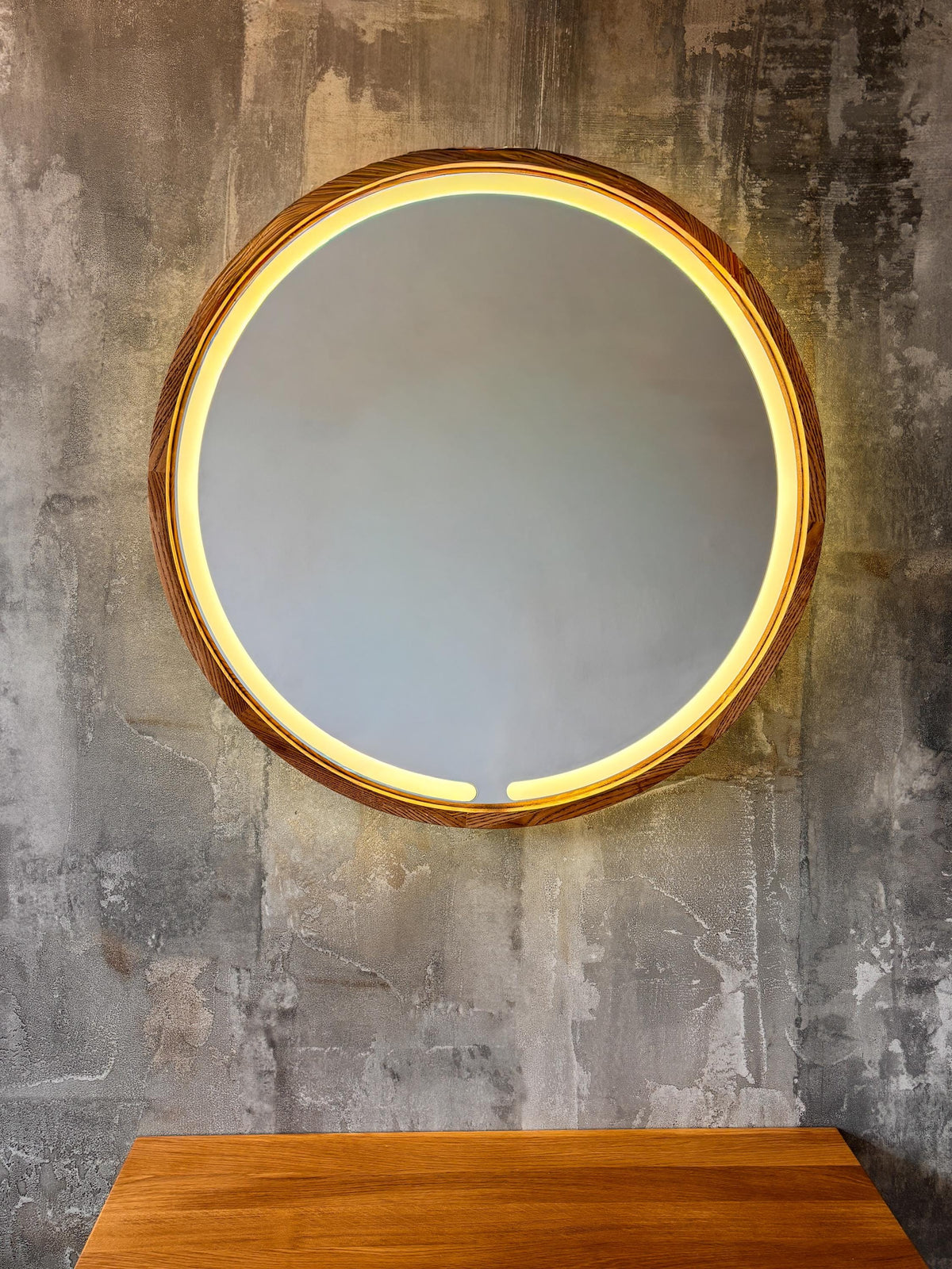 Round LED wood mirror with a soft warm glow