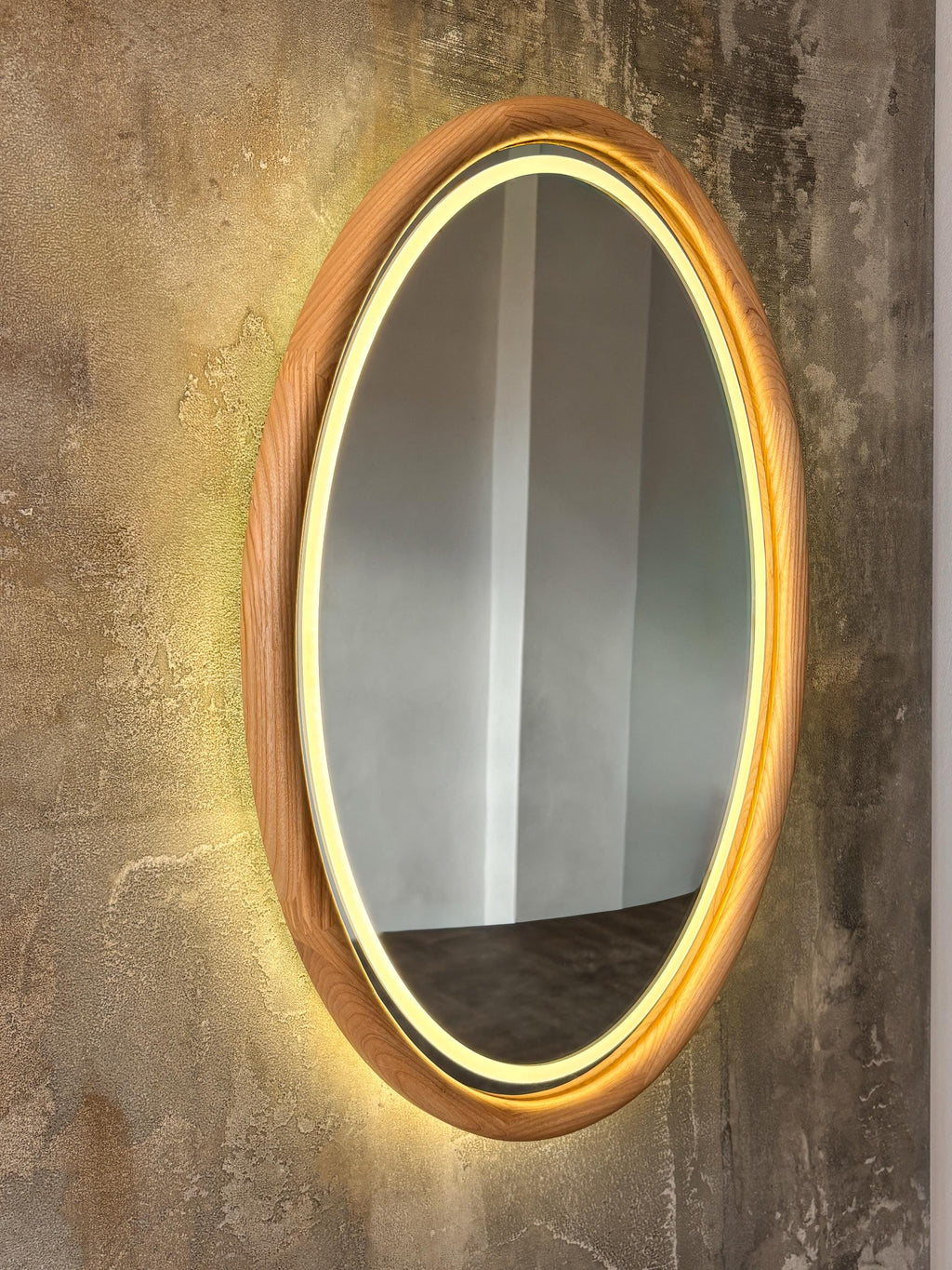 Oval LED wood mirror on a textured wall