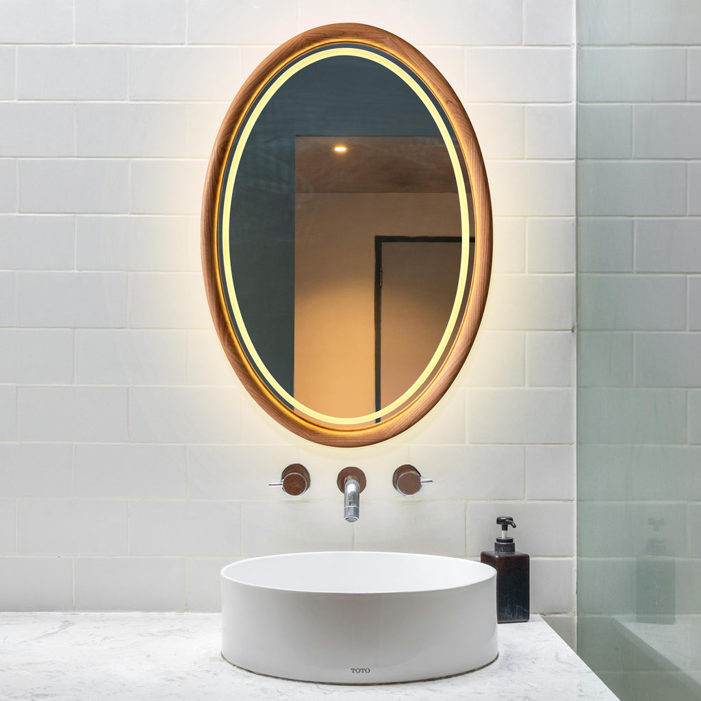 Oval LED mirror above a white basin in a modern bathroom