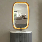 LED rounded rectangle mirror with warm light over a vanity