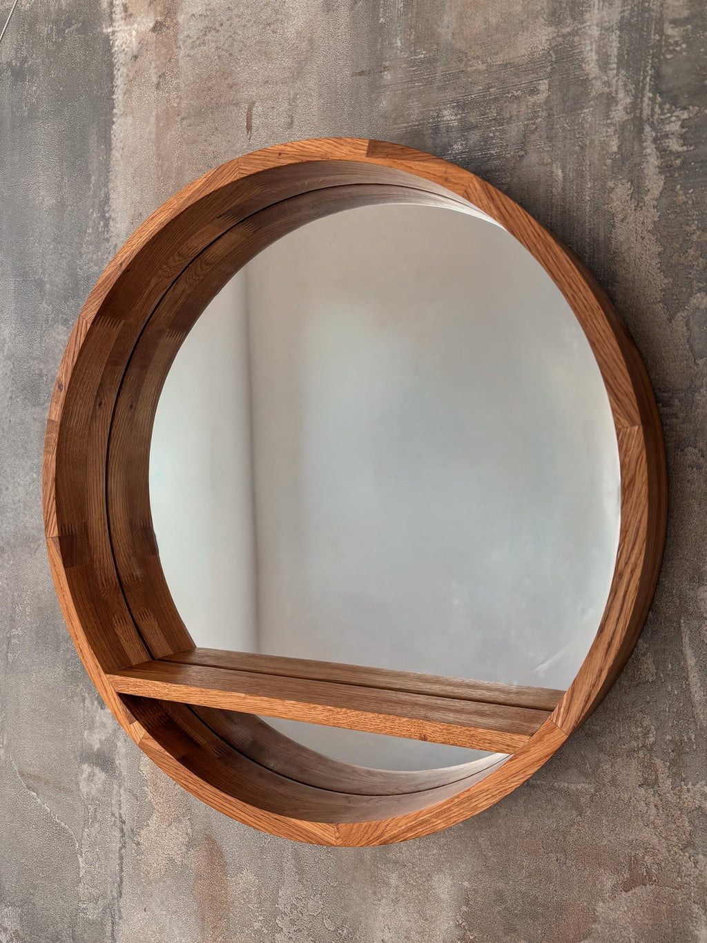 Front view of the round wooden mirror with floating shelf