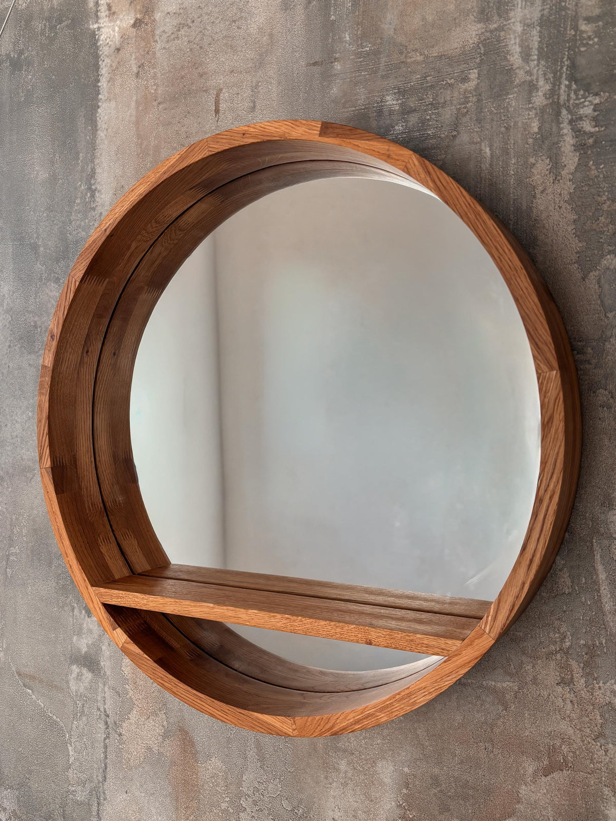 Front view of the round wooden mirror with floating shelf