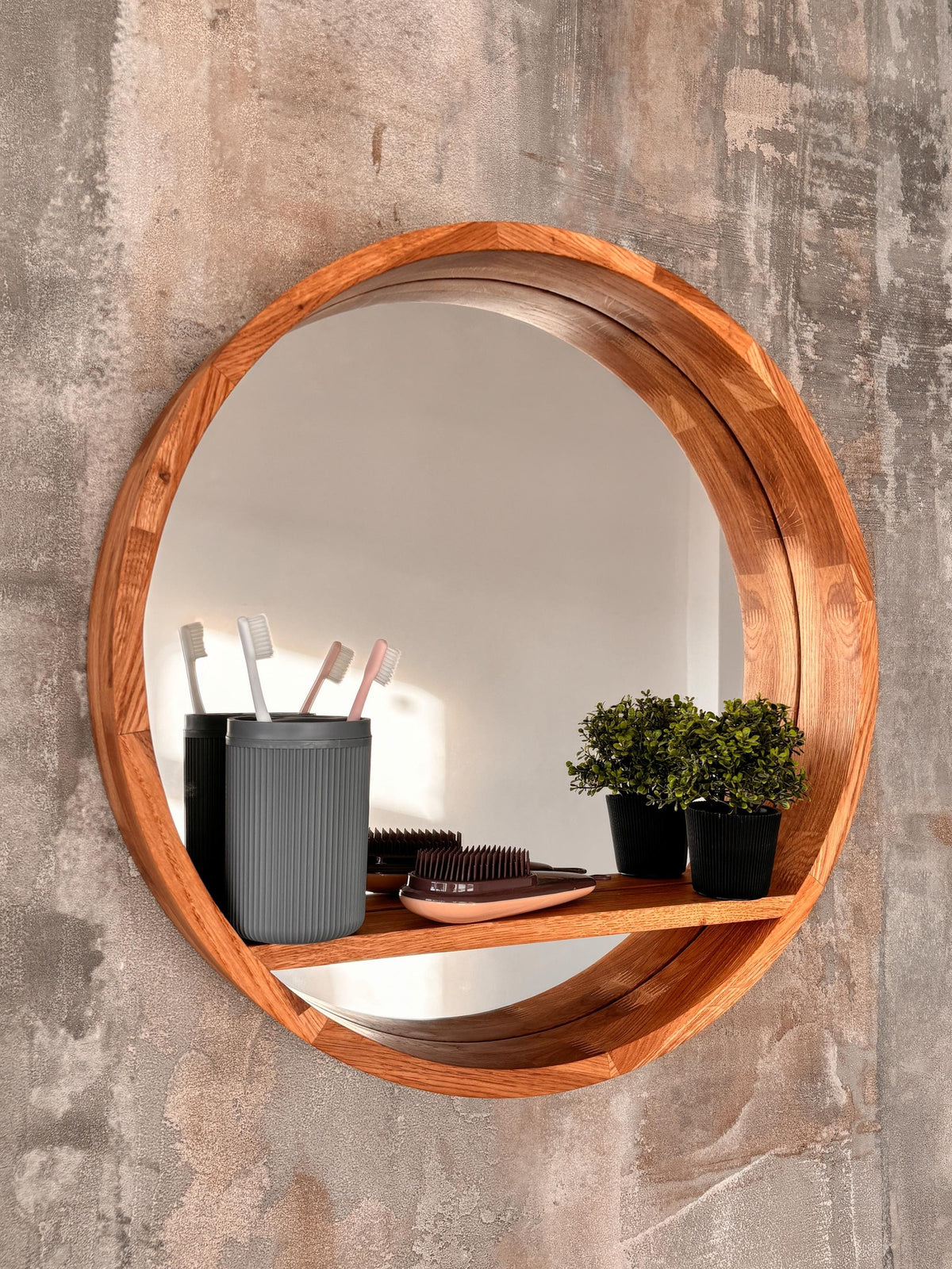 Round wood mirror with a solid oak floating shelf on a wall