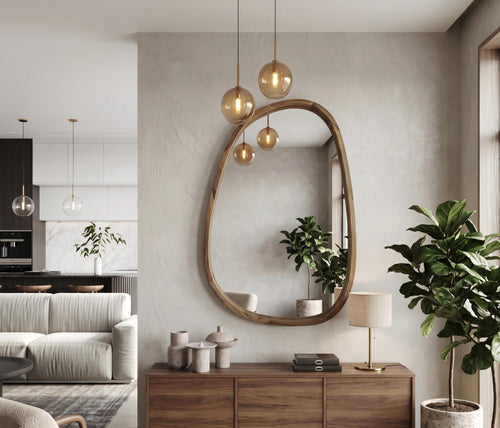 Large pebble-shaped wooden mirror in a living room with pendant lights