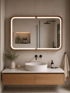 Lighted wood mirror cabinet closed above a bathroom vanity