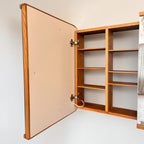 Open cabinet seen from the side with lighted doors