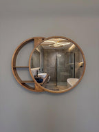 Round mirror with crescent shelving mounted on a wall