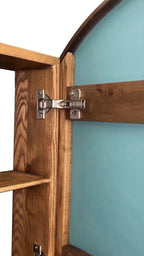Close-up of the cabinet hinge and interior shelf in solid wood