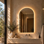 Arched backlit LED bathroom mirror, frameless, over a stone vanity